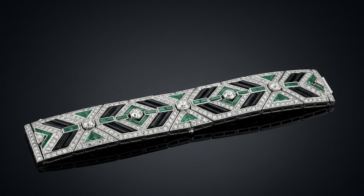 Art-déco-Armband im Cartier-Stil aus Platin mit Smaragd-Baguettes, Onyx-Batons und Diamant-Pavé in geometrischer Komposition auf Marmor.