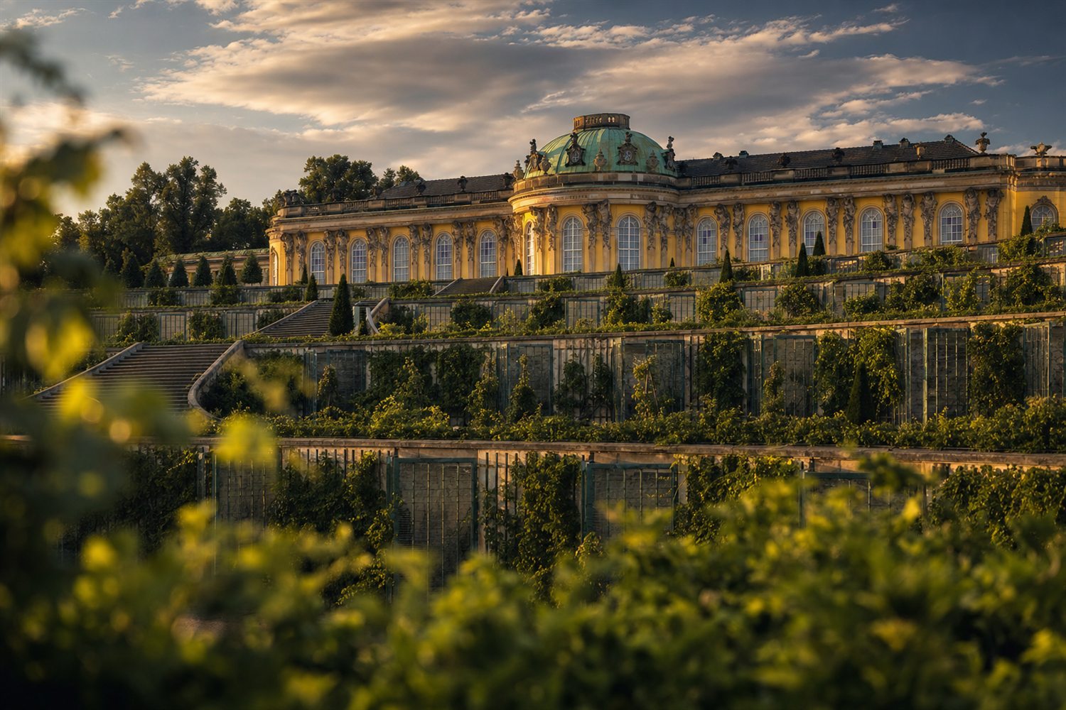 Die gelbe Rokoko-Fassade und der Weinbergterrassen von Schloss Sanssouci in Potsdam im Abendlicht &ndash; Diamant-Ankauf Region Potsdam