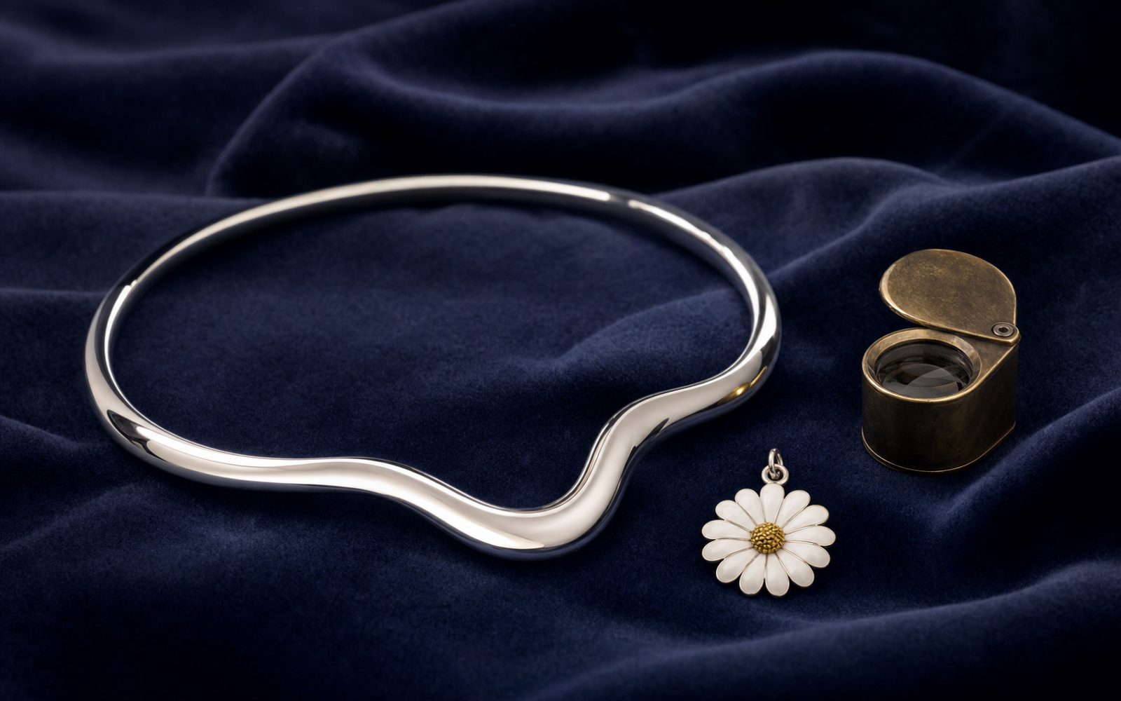 Georg Jensen Moonlight-Grapes-Halsreif und Daisy-Anhänger in Silber auf blauem Samt mit Lupe