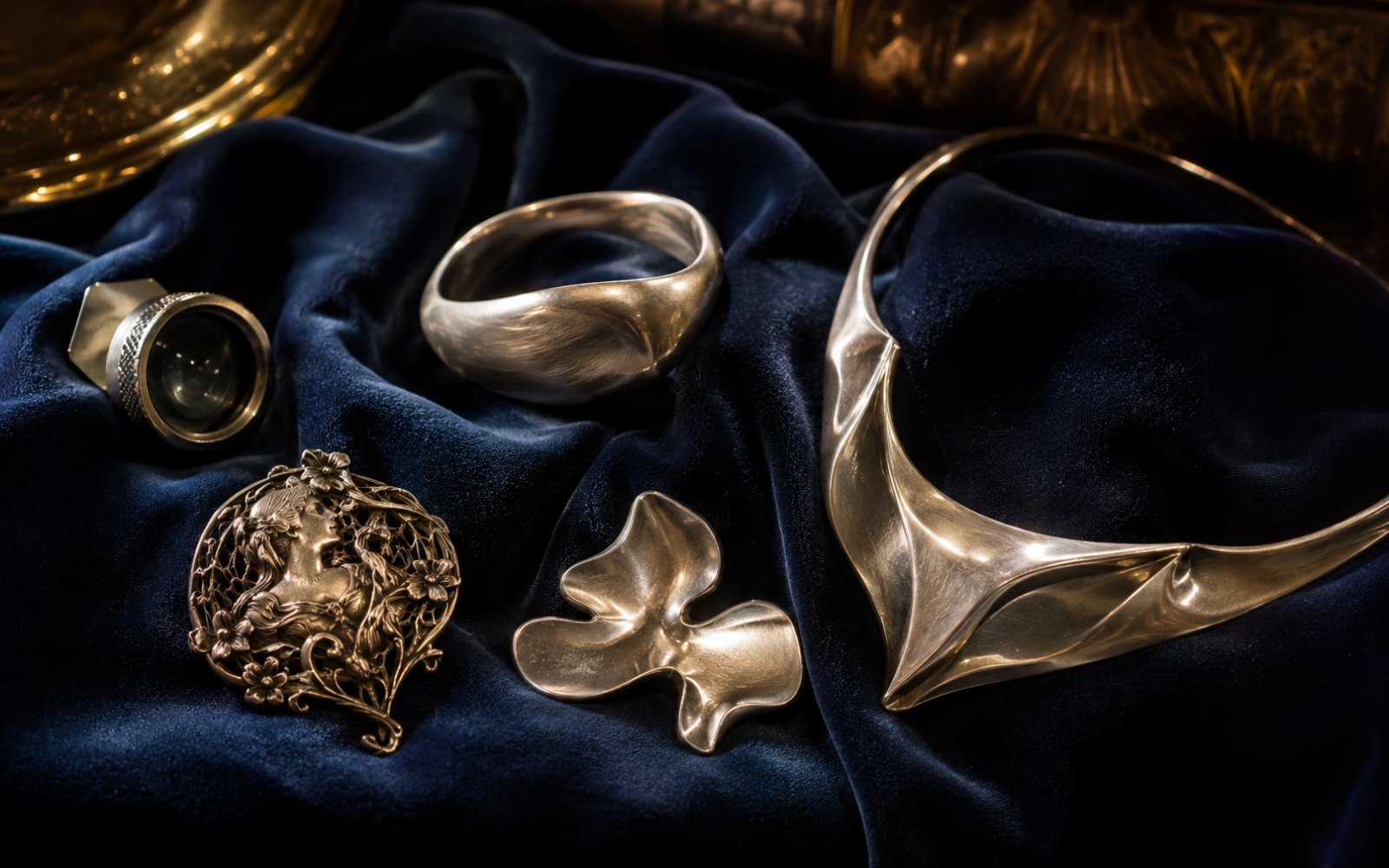 Silberschmuck verschiedener Epochen und Designer, Armreifen, Colliers und Broschen auf dunklem Samt