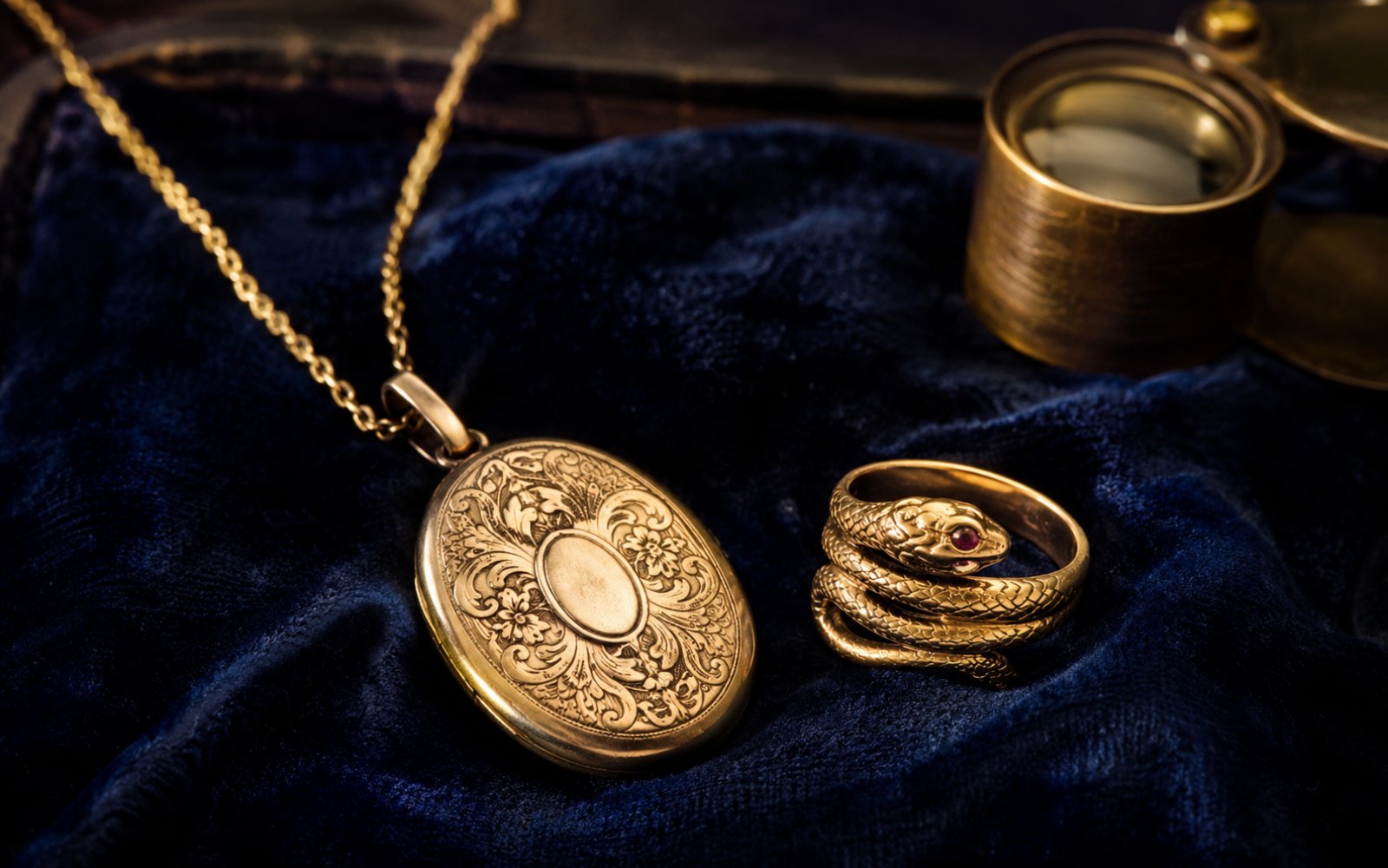 Viktorianisches Gold-Medaillon und Schlangenring auf blauem Samt