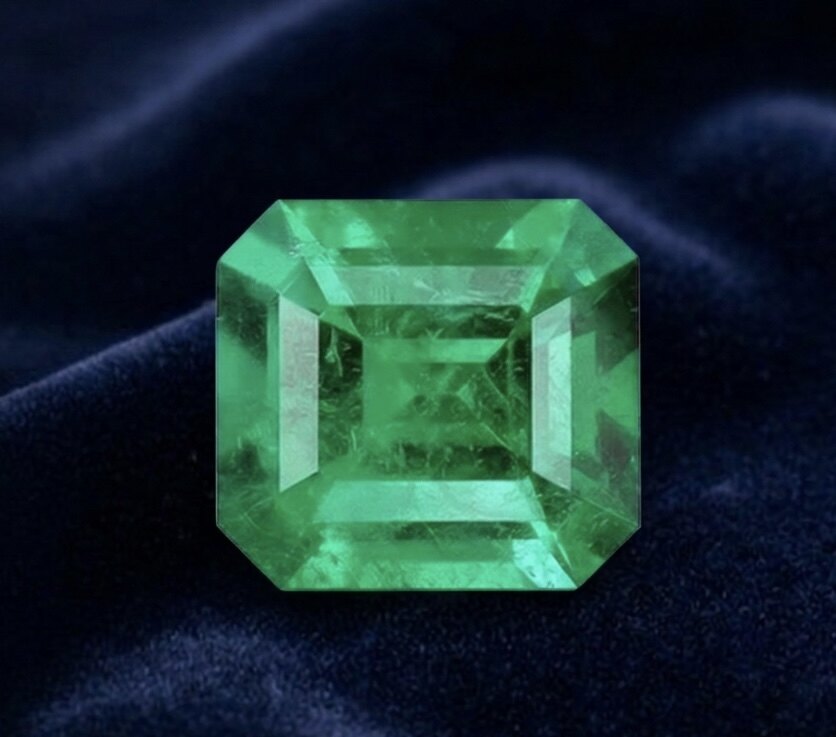 Kolumbianischer Smaragd Emerald-Cut mit Rohkristall auf grünem Samt